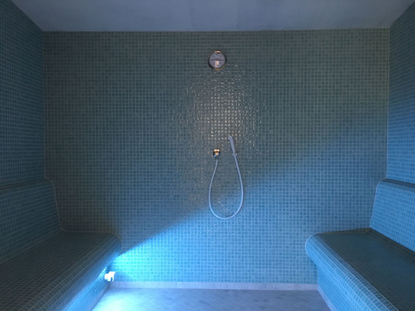 Notranjost turške parne savne z dvema mozaik klopema, prho in modro LED osvetlitvijo – Savne Cafuta